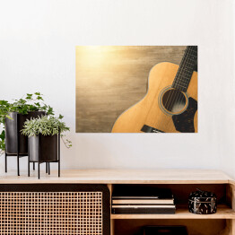 Plakat Gitara akustyczna oświetlona światłem słonecznym na drewnianym tle 