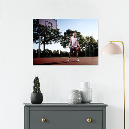 Plakat Wysoki koszykarz z piłką w parku