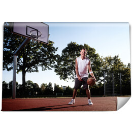 Fototapeta Wysoki koszykarz z piłką w parku