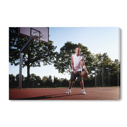 Obraz na płótnie Wysoki koszykarz z piłką w parku