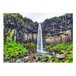 Plakat samoprzylepny Widok na wodospad pośród skał, Islandia