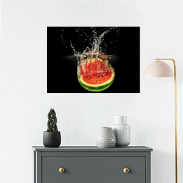 Plakat samoprzylepny Świeży arbuz spadający do wody na czarnym tle