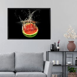 Obraz w ramie Świeży arbuz spadający do wody na czarnym tle
