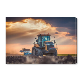 Obraz na płótnie Traktor w polu podczas zachodu słońca