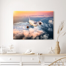 Obraz na płótnie Samolot nad chmurami na kolorowym niebie
