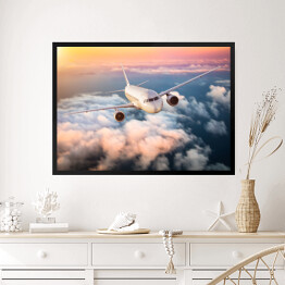 Obraz w ramie Samolot nad chmurami na kolorowym niebie