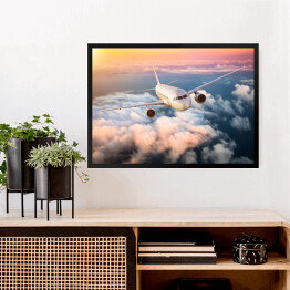 Obraz w ramie Samolot nad chmurami na kolorowym niebie