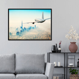 Plakat w ramie Samolot latający nad nowoczesnym miastem w jasnych barwach
