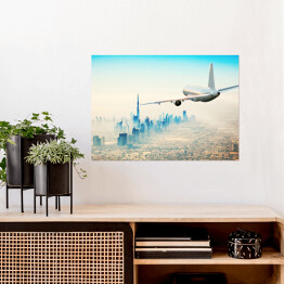 Plakat samoprzylepny Samolot latający nad nowoczesnym miastem w jasnych barwach