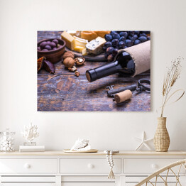 Obraz na płótnie Czerwone wino w butelce oraz ser, oliwki, chleb, orzechy i figi na desce