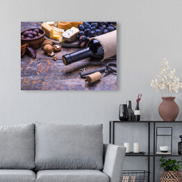 Obraz na płótnie Czerwone wino w butelce oraz ser, oliwki, chleb, orzechy i figi na desce
