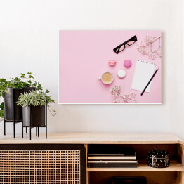 Obraz na płótnie Kawa, ciasto makaron, czysty notatnik, okulary i kwiat na różowym stole