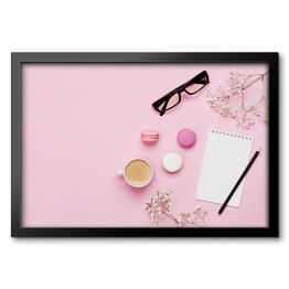 Obraz w ramie Kawa, ciasto makaron, czysty notatnik, okulary i kwiat na różowym stole