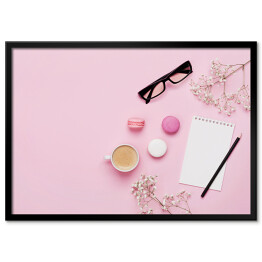 Plakat w ramie Kawa, ciasto makaron, czysty notatnik, okulary i kwiat na różowym stole