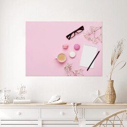 Plakat samoprzylepny Kawa, ciasto makaron, czysty notatnik, okulary i kwiat na różowym stole