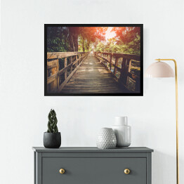 Obraz w ramie Drewniany most oświetlany przez pojedyncze promienie słońca