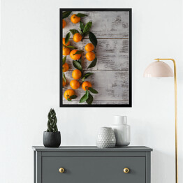 Obraz w ramie Gałązka mandarynek na drewnianym stole