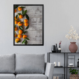Obraz w ramie Gałązka mandarynek na drewnianym stole