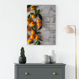 Obraz na płótnie Gałązka mandarynek na drewnianym stole
