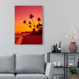 Obraz na płótnie Zachód słońca na tropikalnej plaży z palmami w ciepłych barwach
