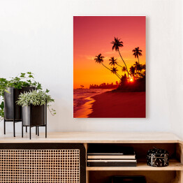 Obraz na płótnie Zachód słońca na tropikalnej plaży z palmami w ciepłych barwach