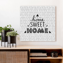 Obraz na płótnie "Nie ma to jak w domu" - typografia na tle imitującym szary ceglany mur 