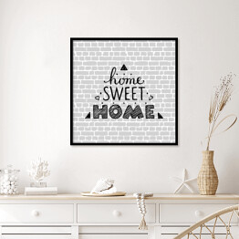 Plakat w ramie "Nie ma to jak w domu" - typografia na tle imitującym szary ceglany mur 