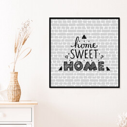 Plakat w ramie "Nie ma to jak w domu" - typografia na tle imitującym szary ceglany mur 