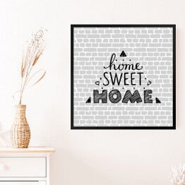 Obraz w ramie "Nie ma to jak w domu" - typografia na tle imitującym szary ceglany mur 