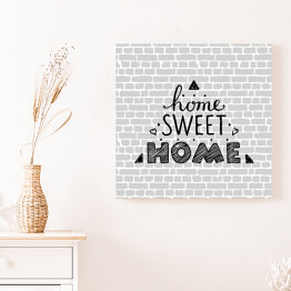 Obraz na płótnie "Nie ma to jak w domu" - typografia na tle imitującym szary ceglany mur 