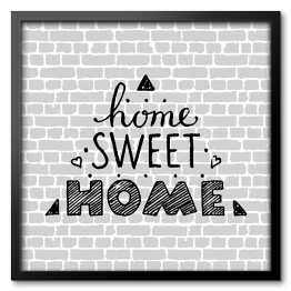 Obraz w ramie "Nie ma to jak w domu" - typografia na tle imitującym szary ceglany mur 