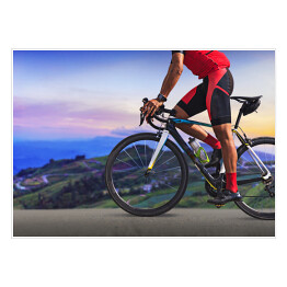 Plakat Mężczyzna na bicyklu na drodze między pięknymi górami