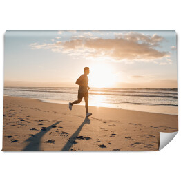 Mężczyzna biegnący rano wzdłuż plaży