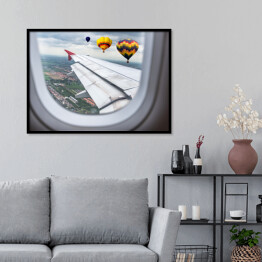 Plakat w ramie Widok za okno samolotu - balony unoszące się nad chmurami