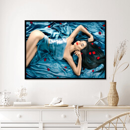 Plakat w ramie Seksowna piękna kobieta z długimi włosami leżąca na łóżku