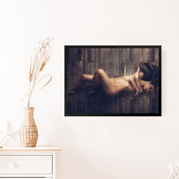 Obraz w ramie Młoda naga kobieta leżąca na drewnianej podłodze