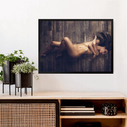 Obraz w ramie Młoda naga kobieta leżąca na drewnianej podłodze