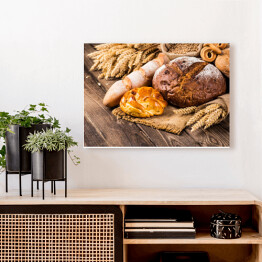 Obraz na płótnie Kłosy zbóż oraz chleb na drewnianym stole
