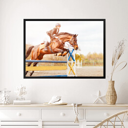 Obraz w ramie Podpalany koń z dziewczyną skaczący nad przeszkodą 