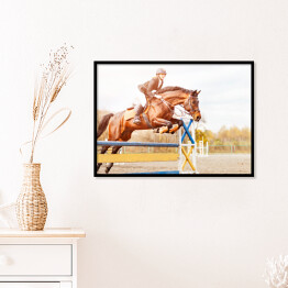 Plakat w ramie Podpalany koń z dziewczyną skaczący nad przeszkodą 