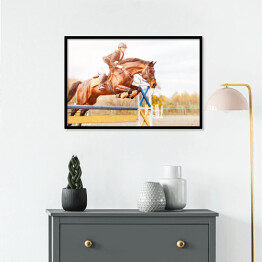 Plakat w ramie Podpalany koń z dziewczyną skaczący nad przeszkodą 