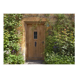 Plakat Brązowe drewniane drzwi w starym tradycyjnym angielskim domu z kwiatami w letni dzień