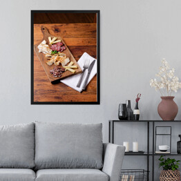 Obraz w ramie Sery i wędliny sery na drewnianej desce na rustykalnym stole