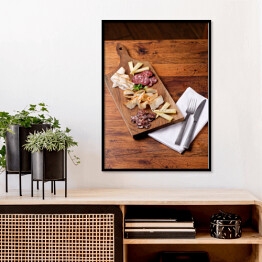 Plakat w ramie Sery i wędliny sery na drewnianej desce na rustykalnym stole