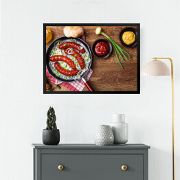 Obraz w ramie Smażone kiełbaski na patelni z cebulą