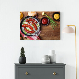 Obraz na płótnie Smażone kiełbaski na patelni z cebulą