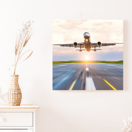 Obraz na płótnie Samolotowa zwiększający prędkość na pasie startowym o świcie