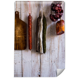 Fototapeta winylowa zmywalna Wędliny i kiełbasy wiszące na haku na drewnianym tle
