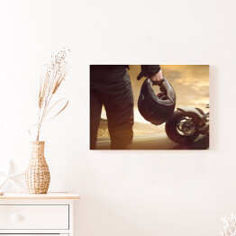 Obraz na płótnie Motocyklista stojący z kaskiem na drodze