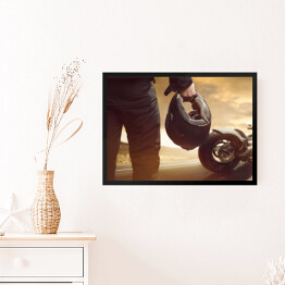 Obraz w ramie Motocyklista stojący z kaskiem na drodze